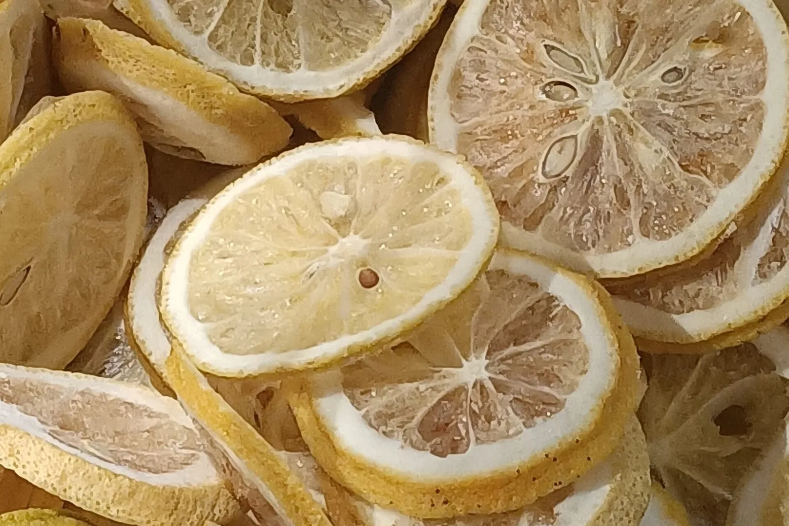 A layer of pale yellow dried lemon slices seen from above.