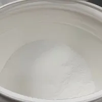 An open tub filled with fine white creatine powder.