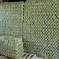 Hundreds of olive-green bars of traditional soap stacked into tall walls to cure.