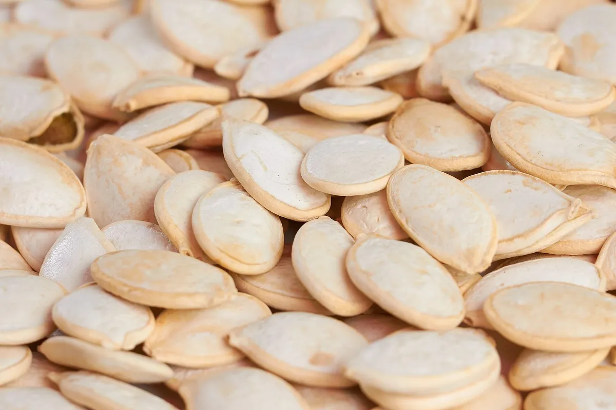 A close-up of cream-coloured pumpkin seeds piled together