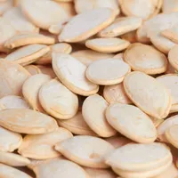 A close-up of cream-coloured pumpkin seeds piled together.