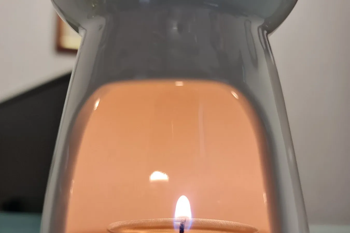 A tealight glowing inside a white ceramic oil burner